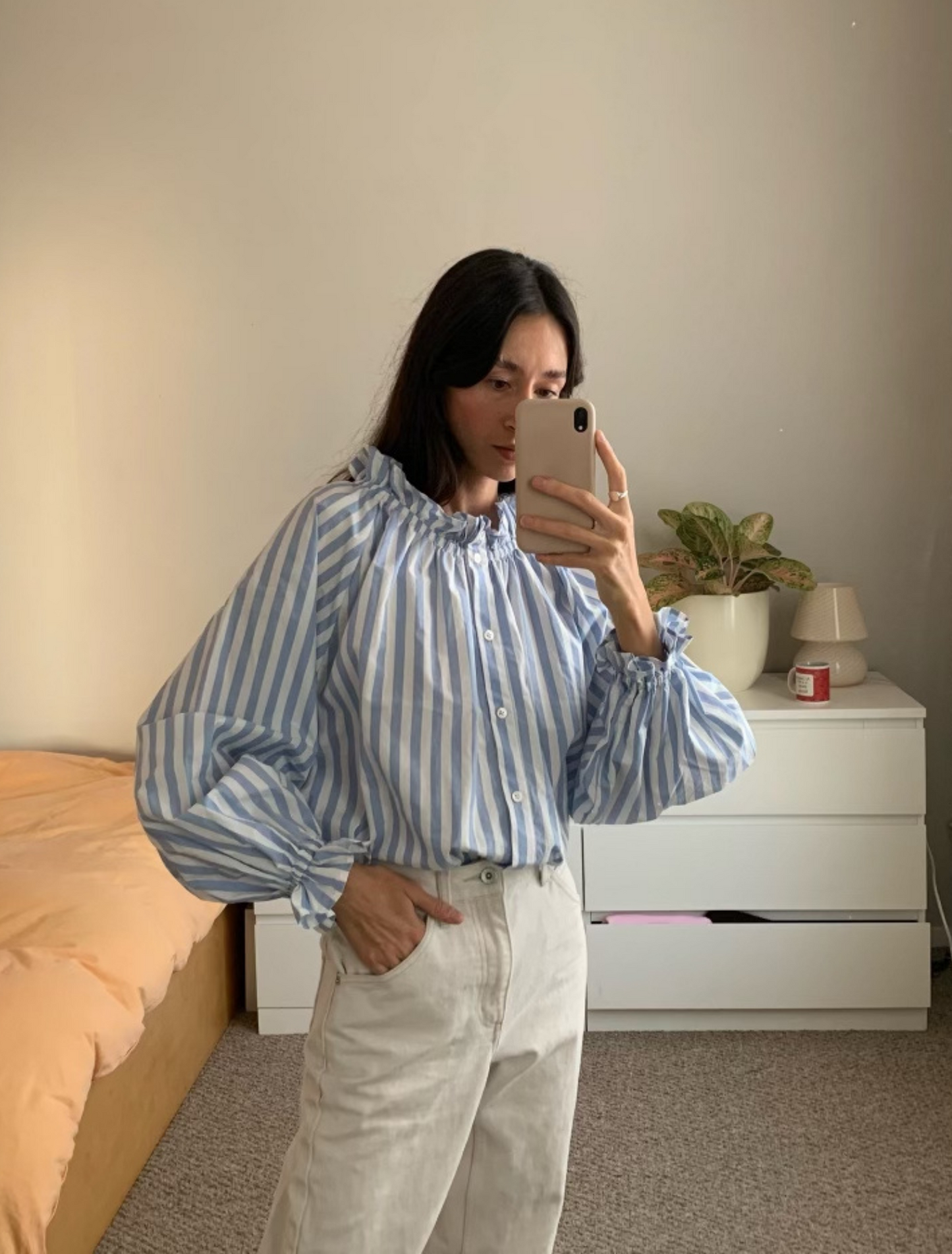 Light blue stripe cotton blouse with soft ruffles at the neck and wrists.