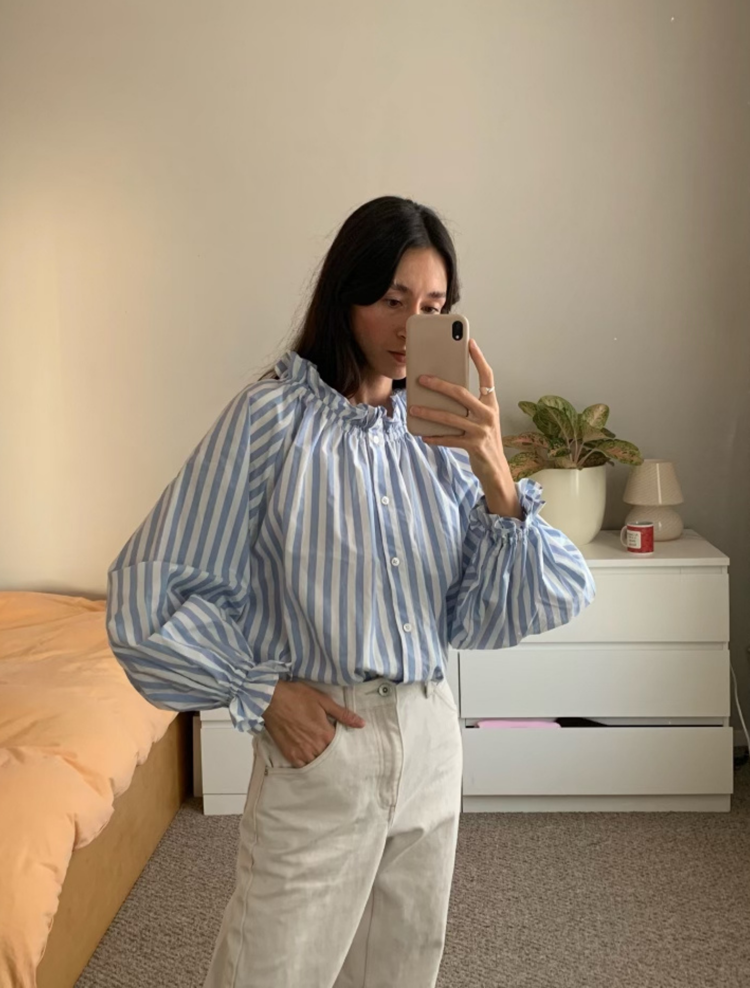 Light blue stripe cotton blouse with soft ruffles at the neck and wrists.