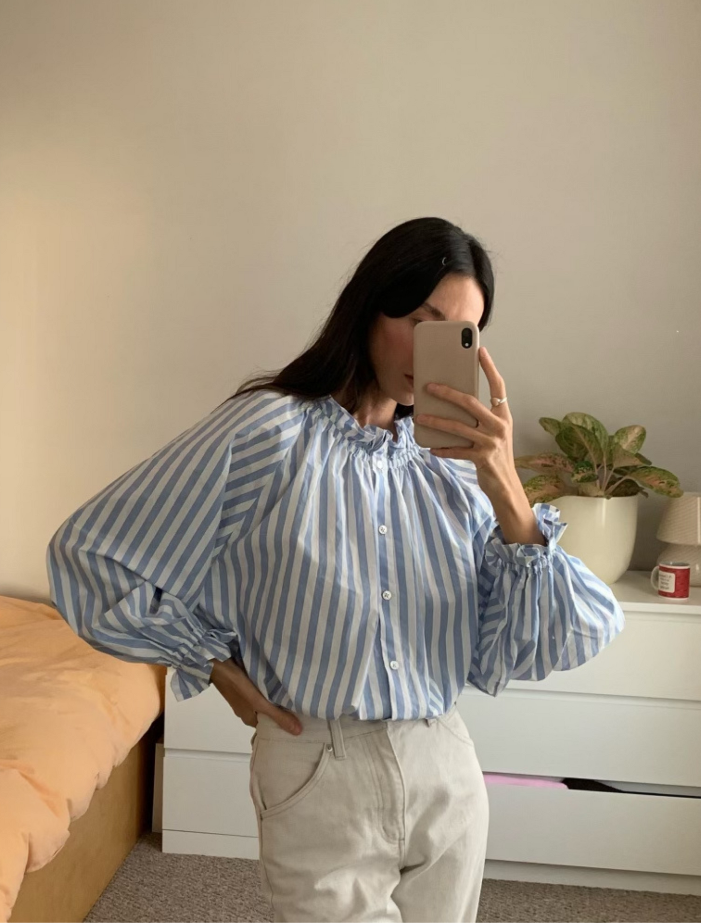 Light blue stripe cotton blouse with soft ruffles at the neck and wrists.