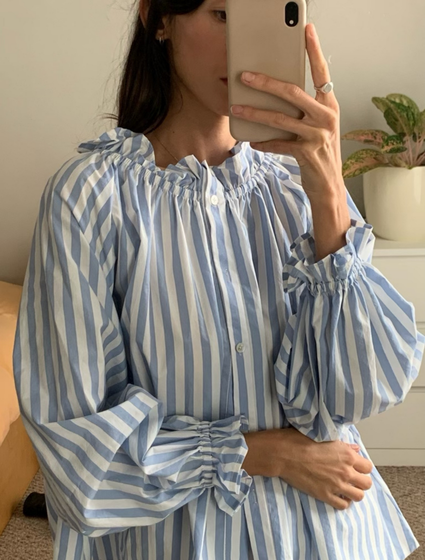 Light blue stripe cotton blouse with soft ruffles at the neck and wrists.