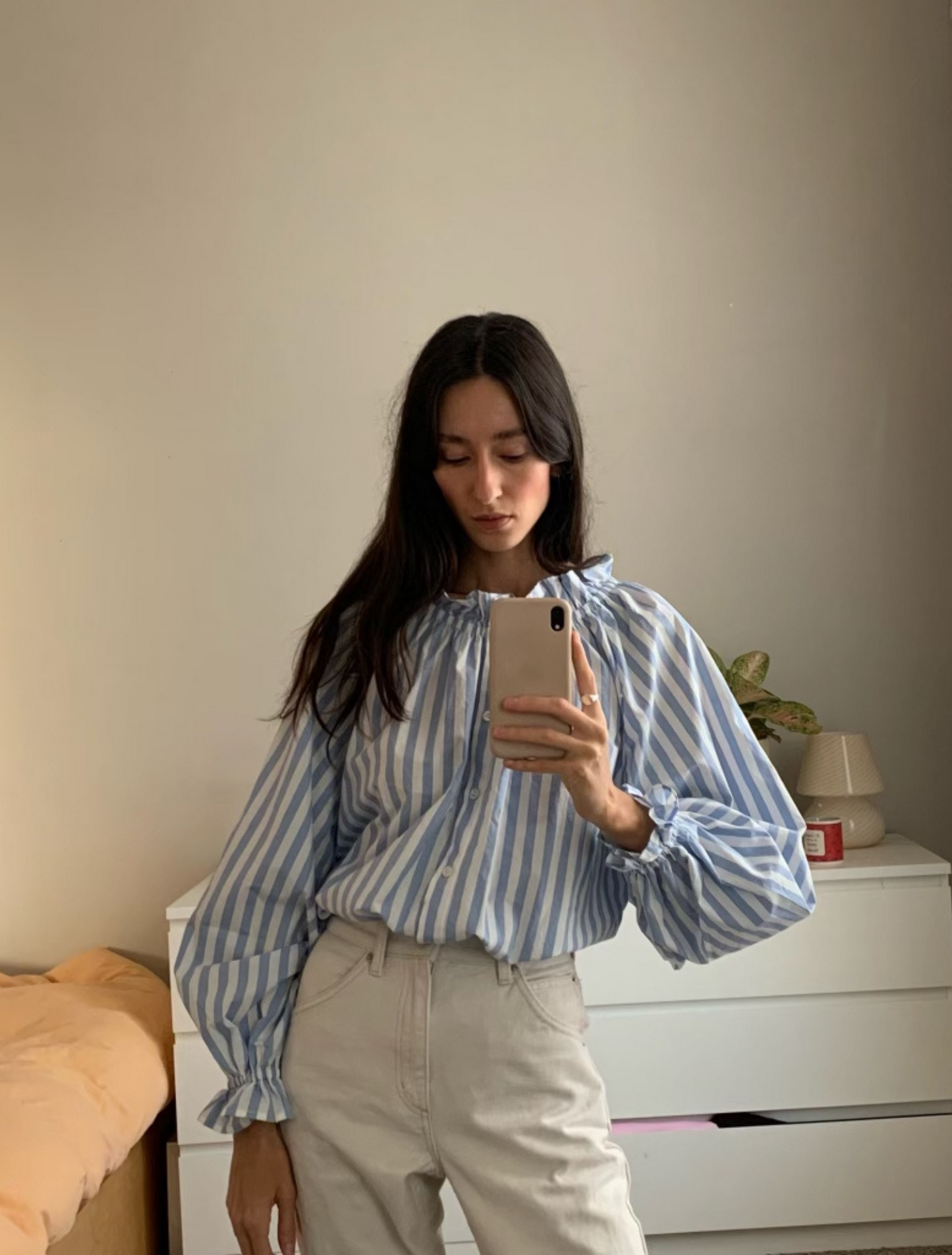Light blue stripe cotton blouse with soft ruffles at the neck and wrists.